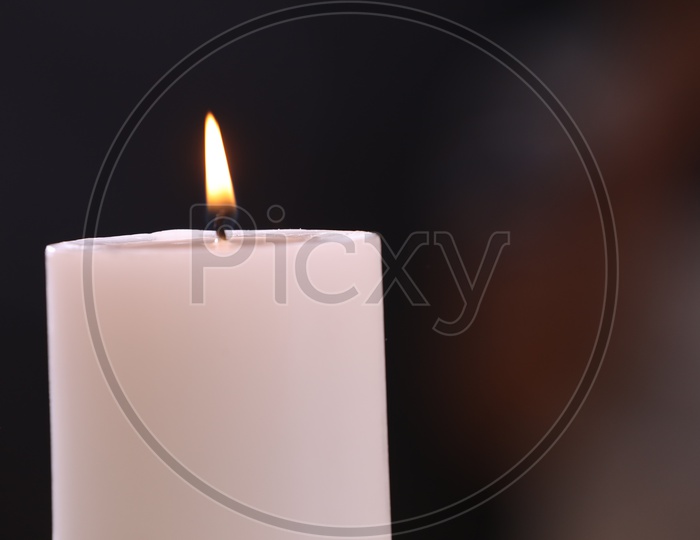 Lit Candle On an Isolated Black Background