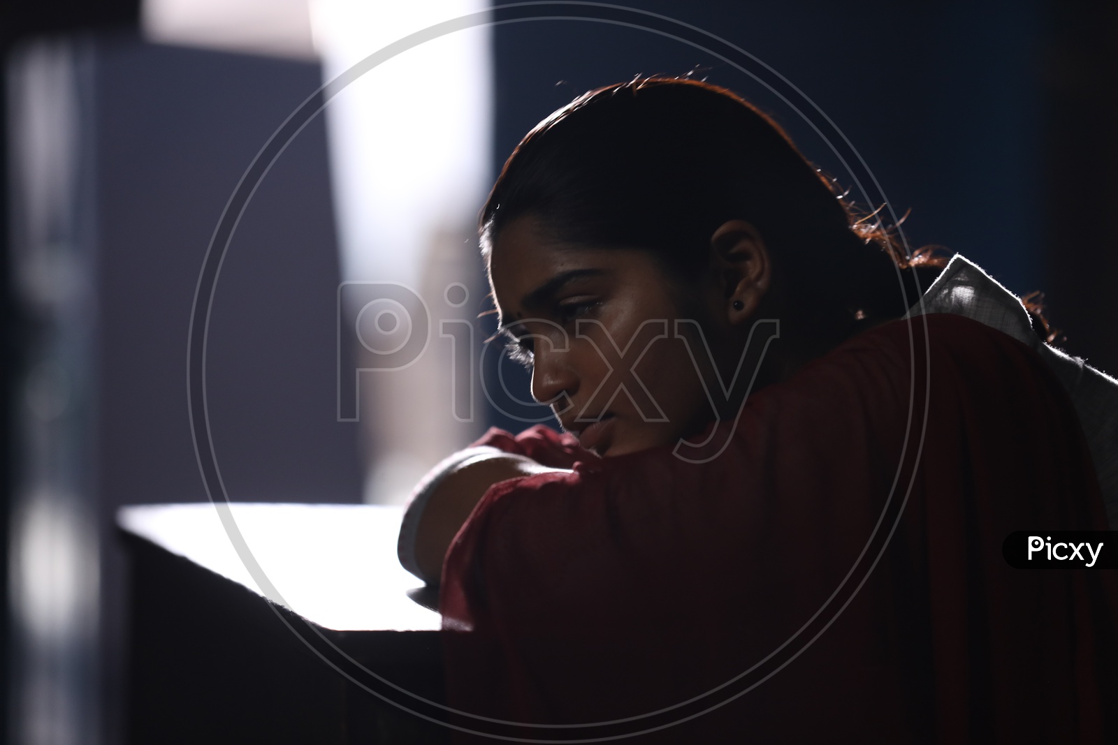 A Girl Sitting Sadly In a Classroom With Dark Light ambiance