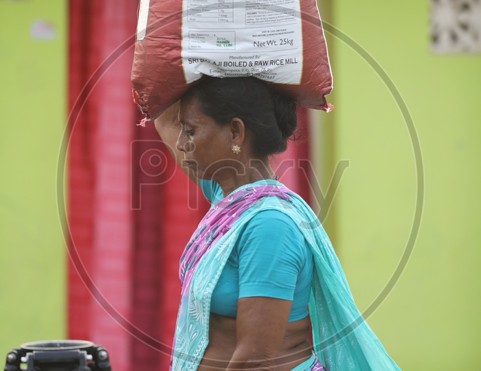 A Rural Indian Woman Carrying The Heavy Weights On Her Head