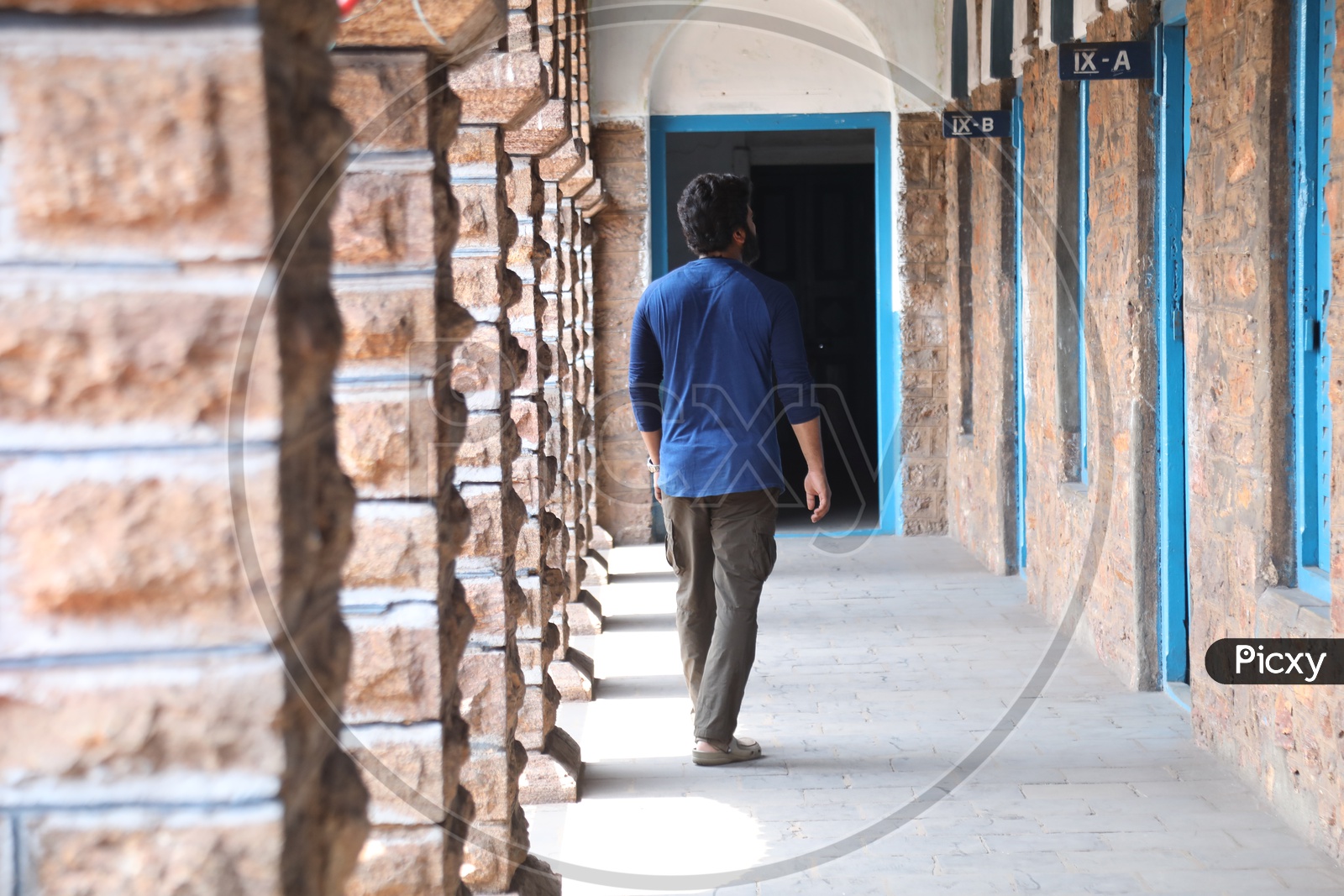 A Young Man Walking in a School Corridor