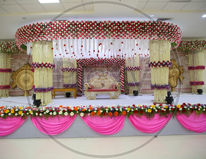 Stage Decorated  With Fresh  Flowers And Sofa Arranged For Couple  In a Wedding Reception