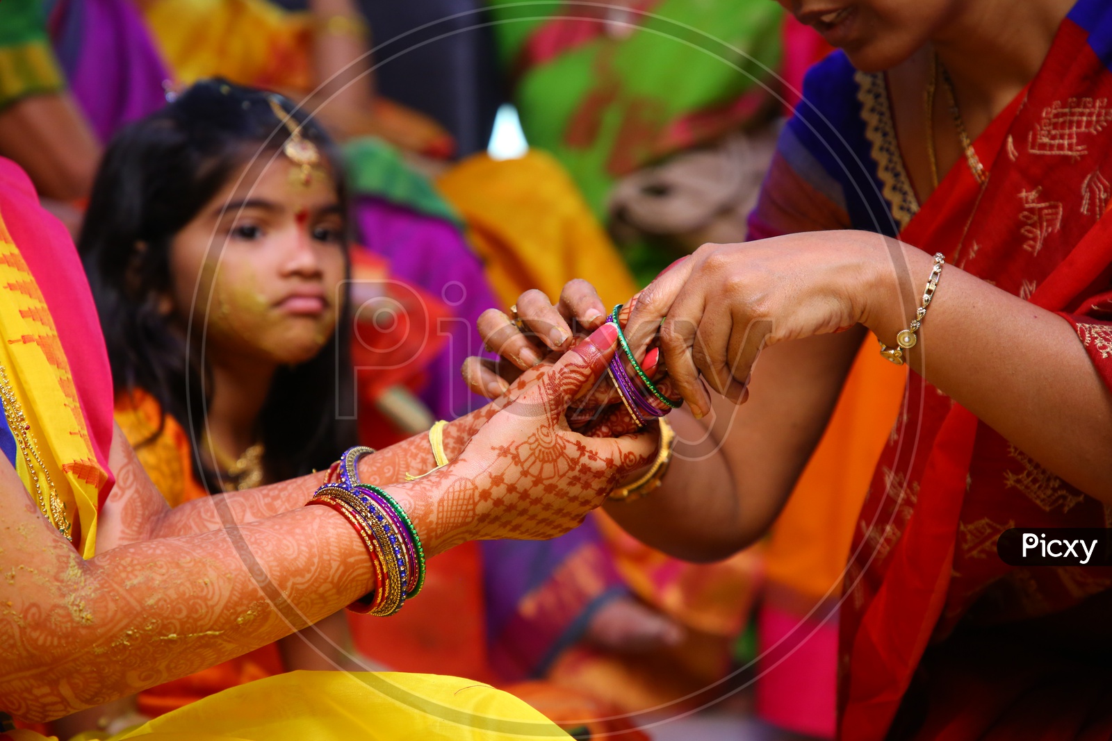 Relatives Wearing Bangles To Bride Hands In Wedding Rituals