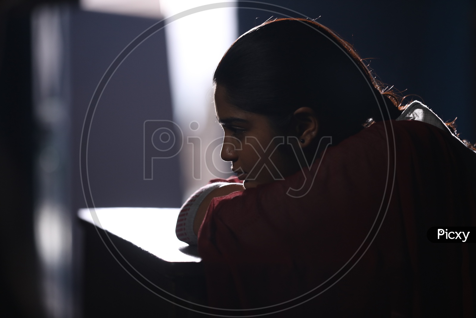 A Girl Sitting Sadly In a Classroom With Dark Light ambiance