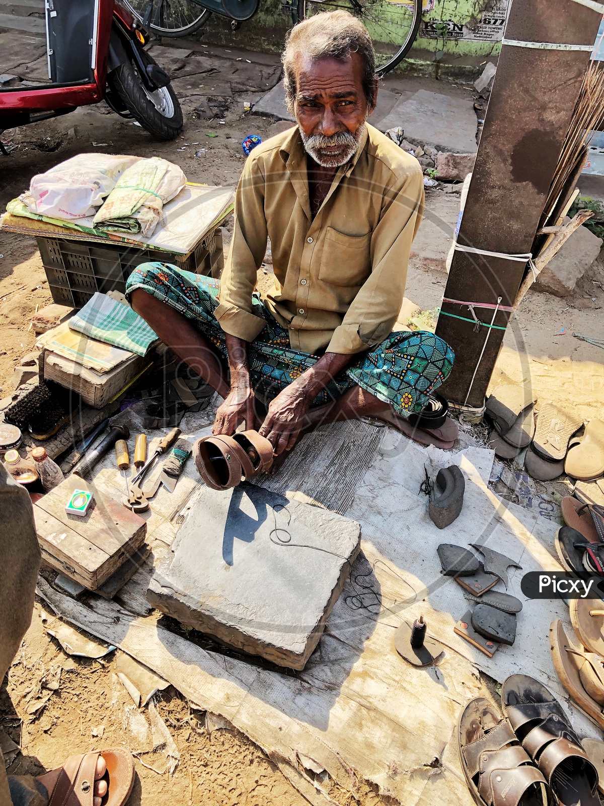 Old man working repairing footwear