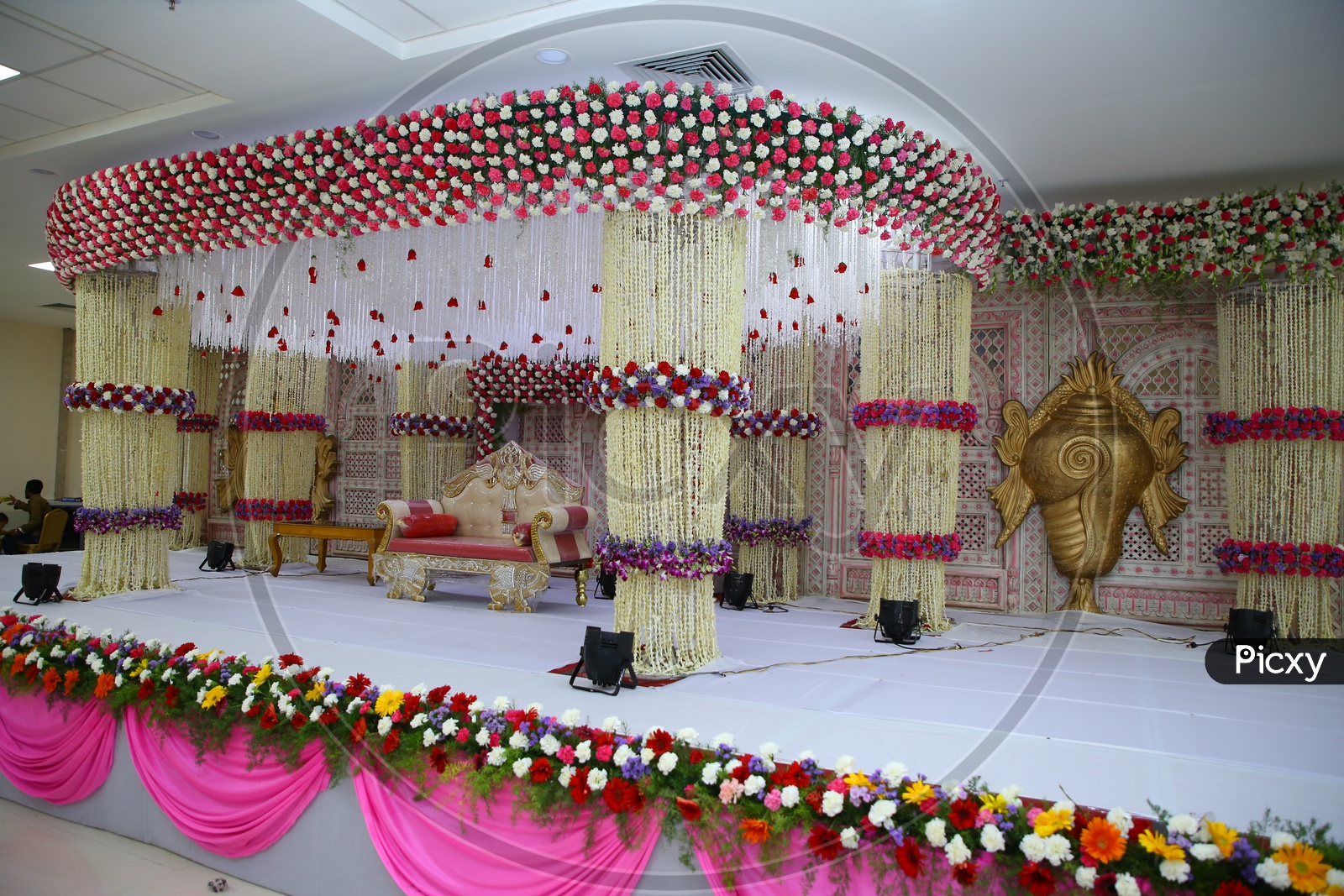 Stage Decorated  With Fresh  Flowers And Sofa Arranged For Couple  In a Wedding Reception