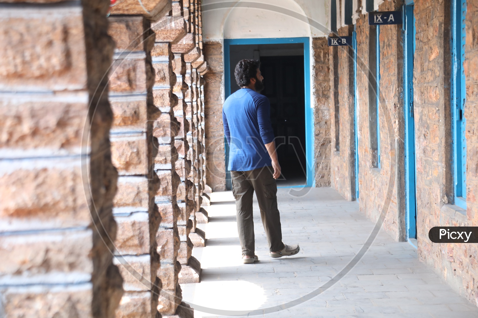 A Young Man Walking in a School Corridor
