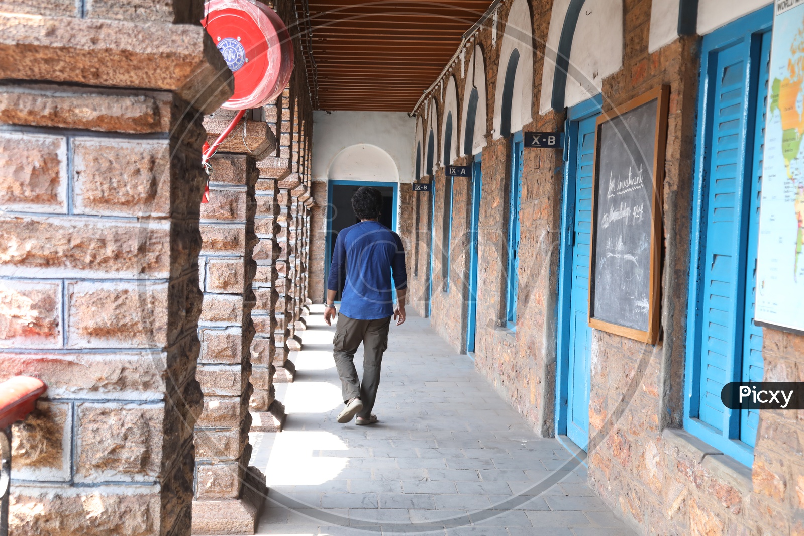 A man Walking Alone In a School Corridor or Solitude