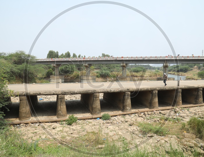 A Dried Water Channel With Pit Water Ponds And Bridge Over The Water Channel