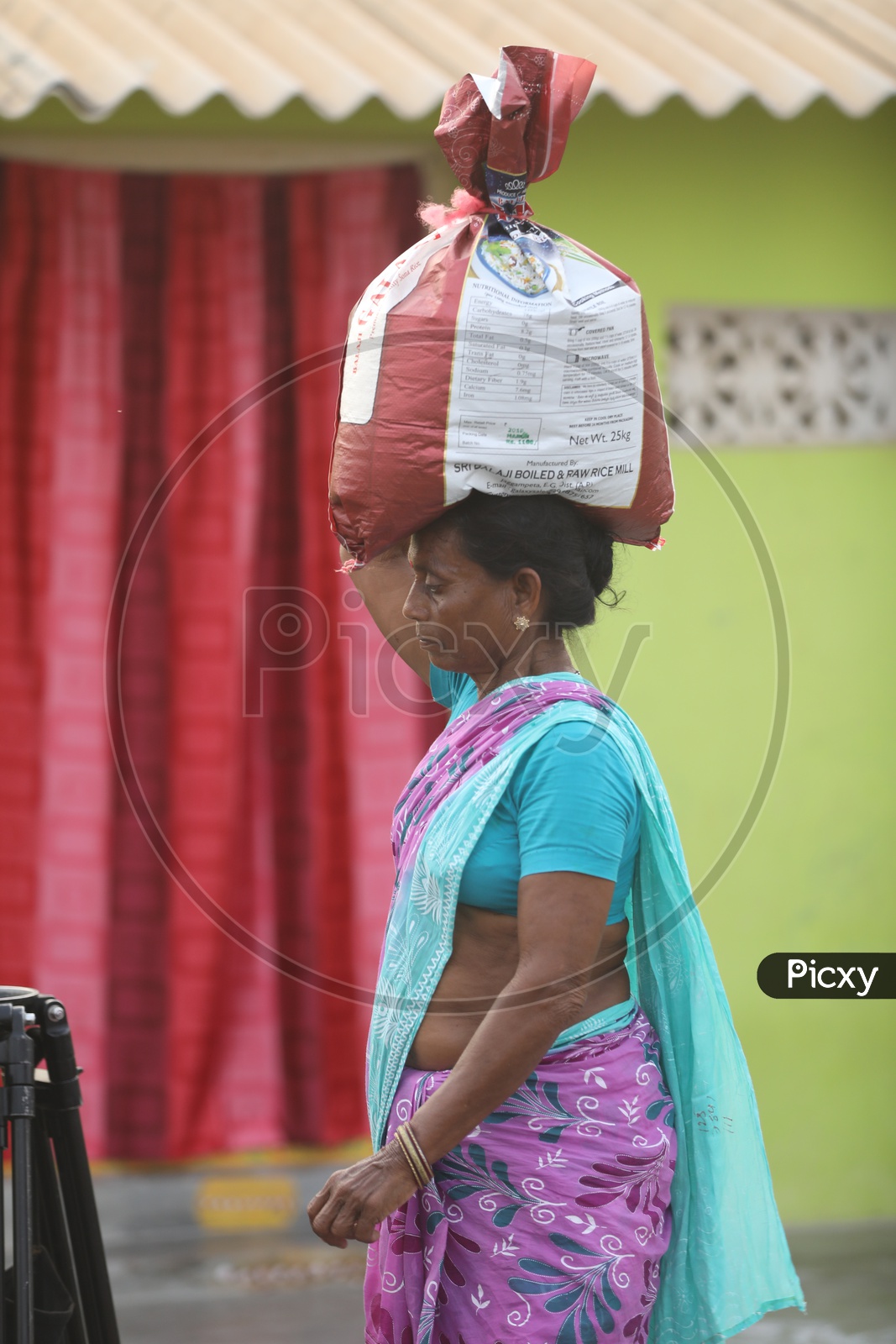 A Rural Indian Woman Carrying The Heavy Weights On Her Head