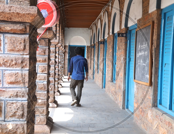 A man Walking Alone In a School Corridor or Solitude