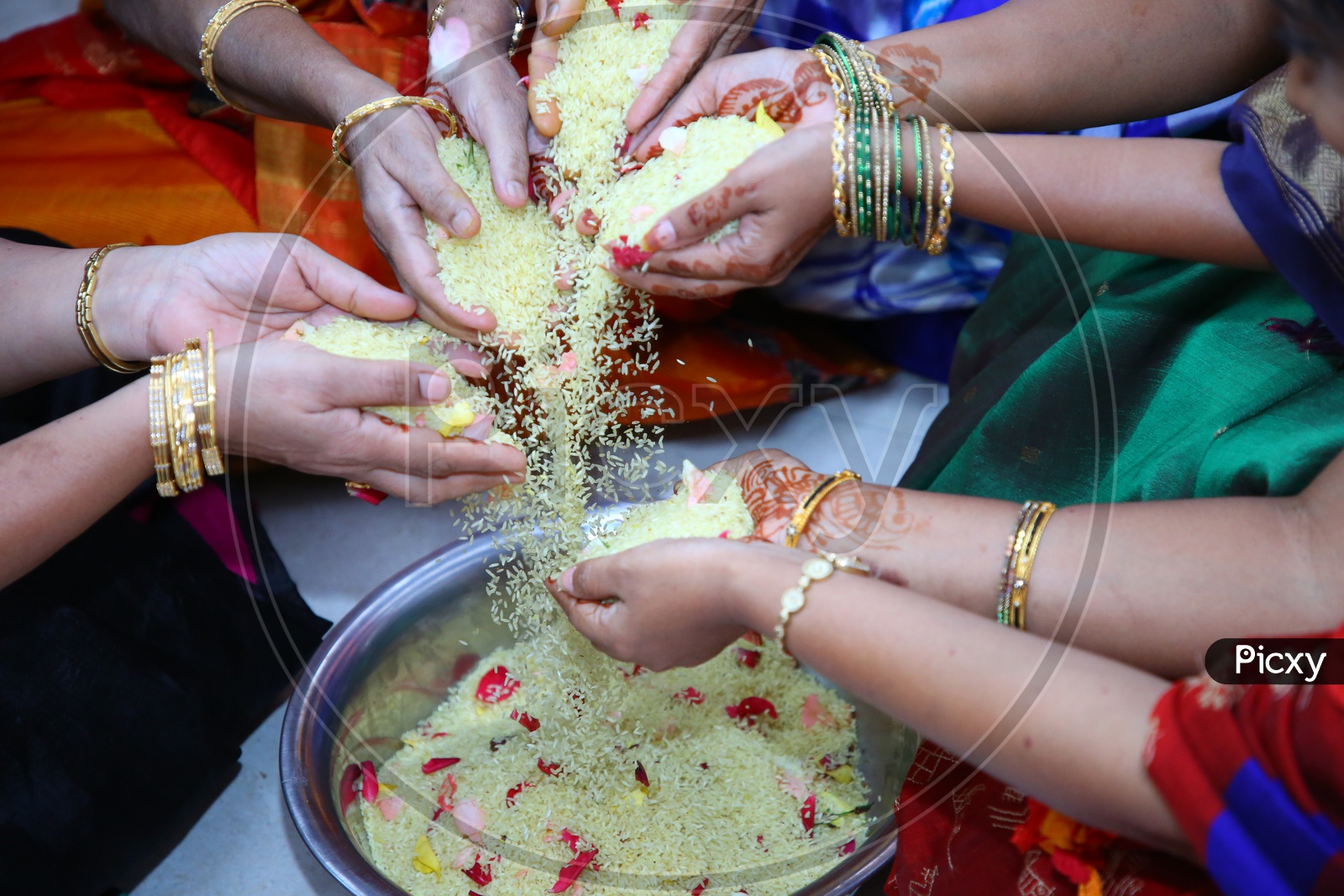 Woman Or Ladies Hands Mixing Turmeric Coated Rice  Or Akshintalu  In a Wedding Function