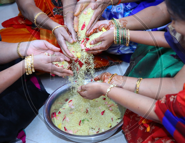 Woman Or Ladies Hands Mixing Turmeric Coated Rice  Or Akshintalu  In a Wedding Function