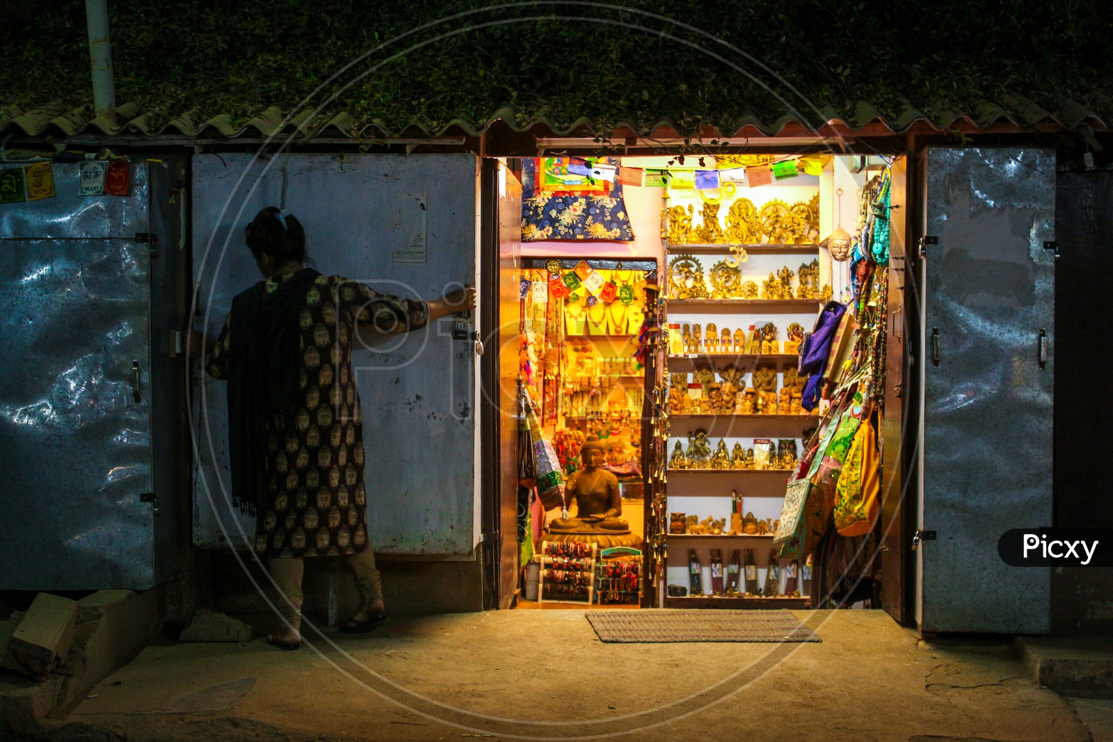 Shopkeeper closing the shop in the streets of Hampi during night