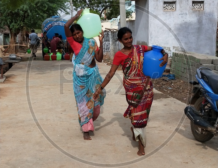 Women carrying their buckets in scorching heat