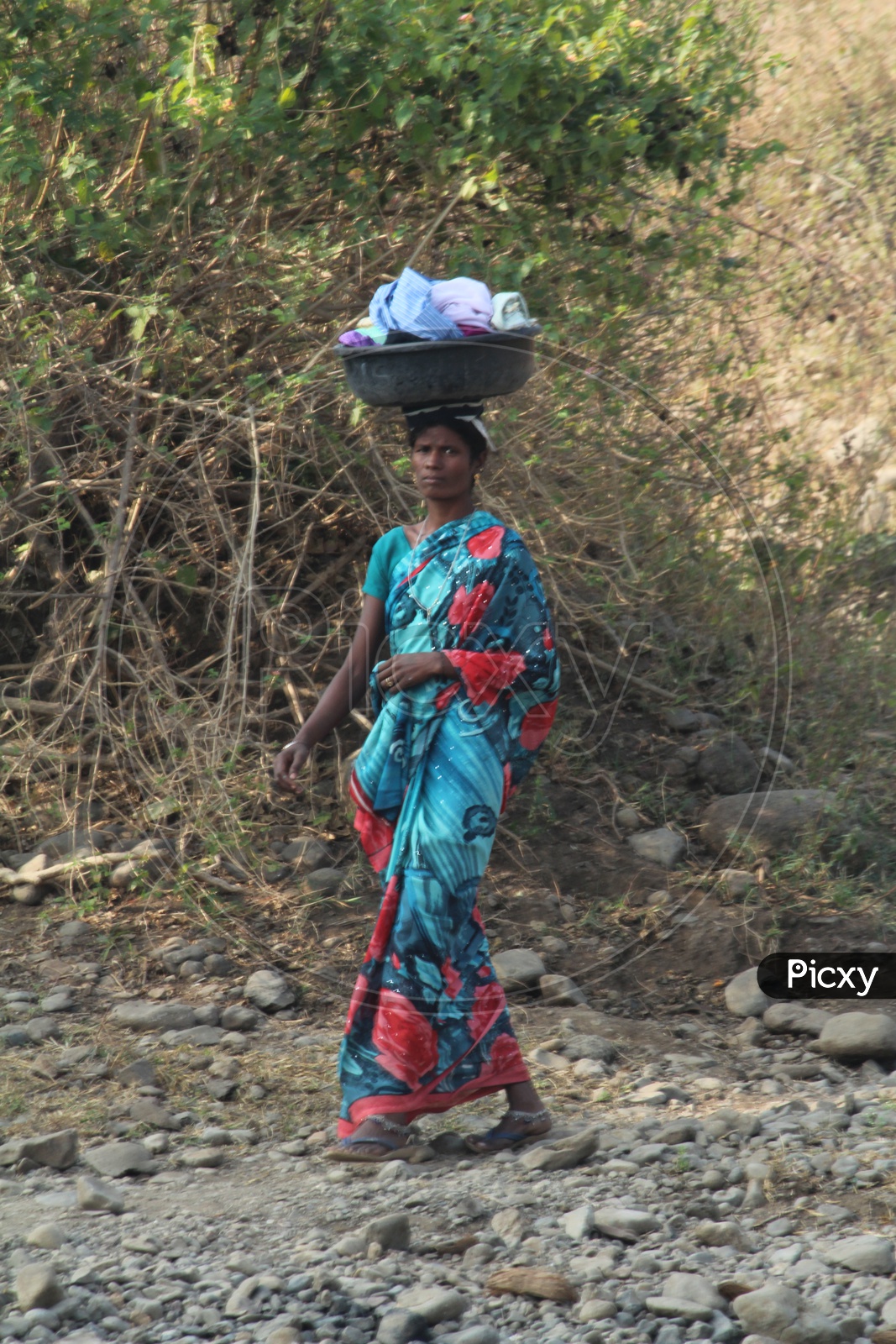women carrying clothes for washing