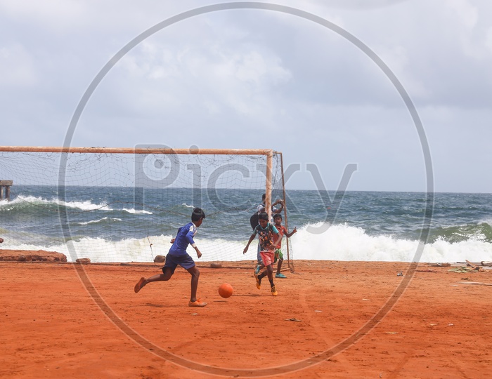children playing football in beach