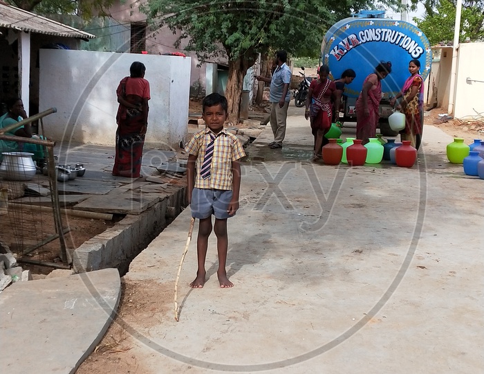 A little boy posing innocently while their parents are struggling for water