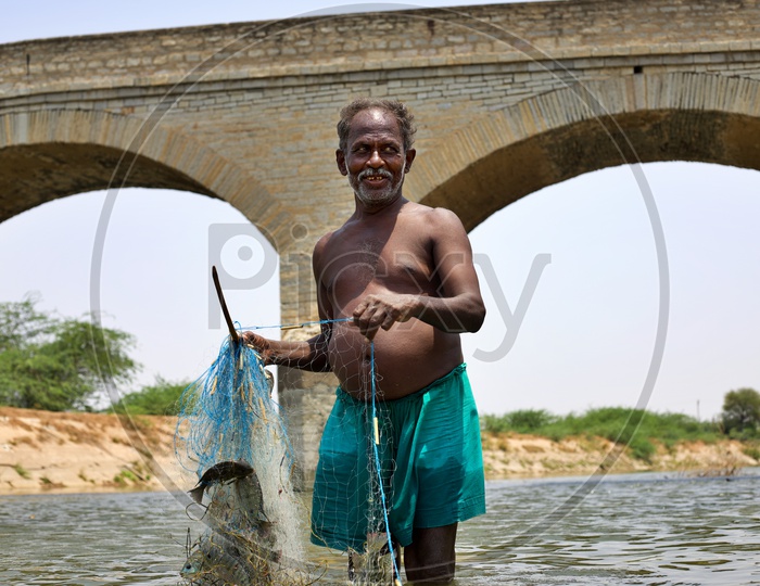 A fisher man placing his net in water.