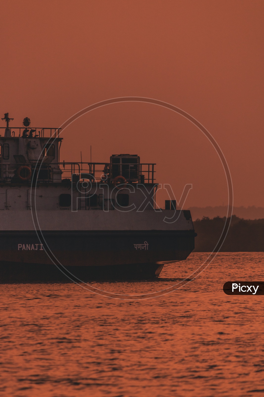 a ship on  Mandovi River at the time of golden hour