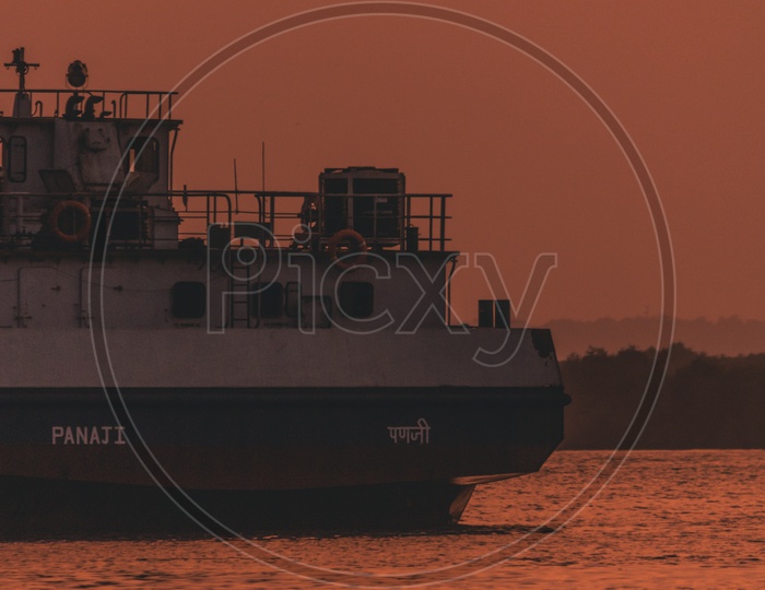 a ship on  Mandovi River at the time of golden hour