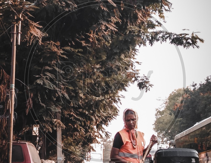 A GHMC  Sanitary Employee Sweeping The Streets