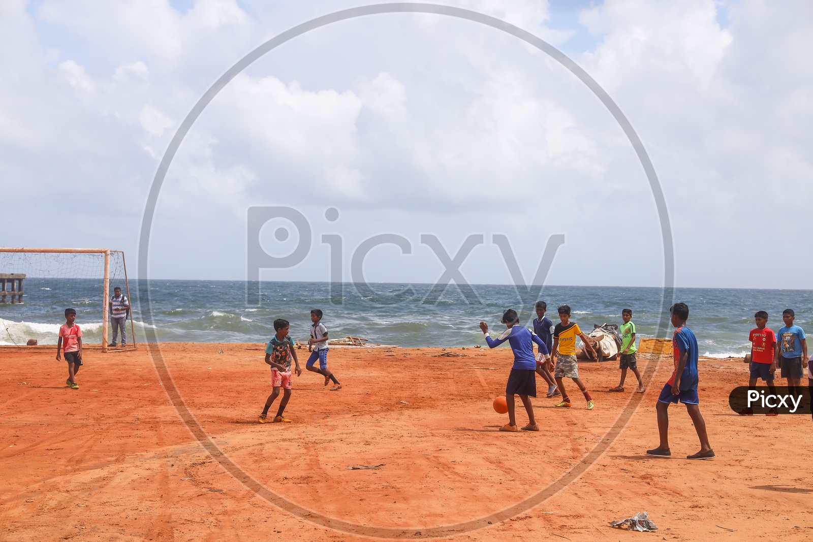 children playing football in beach