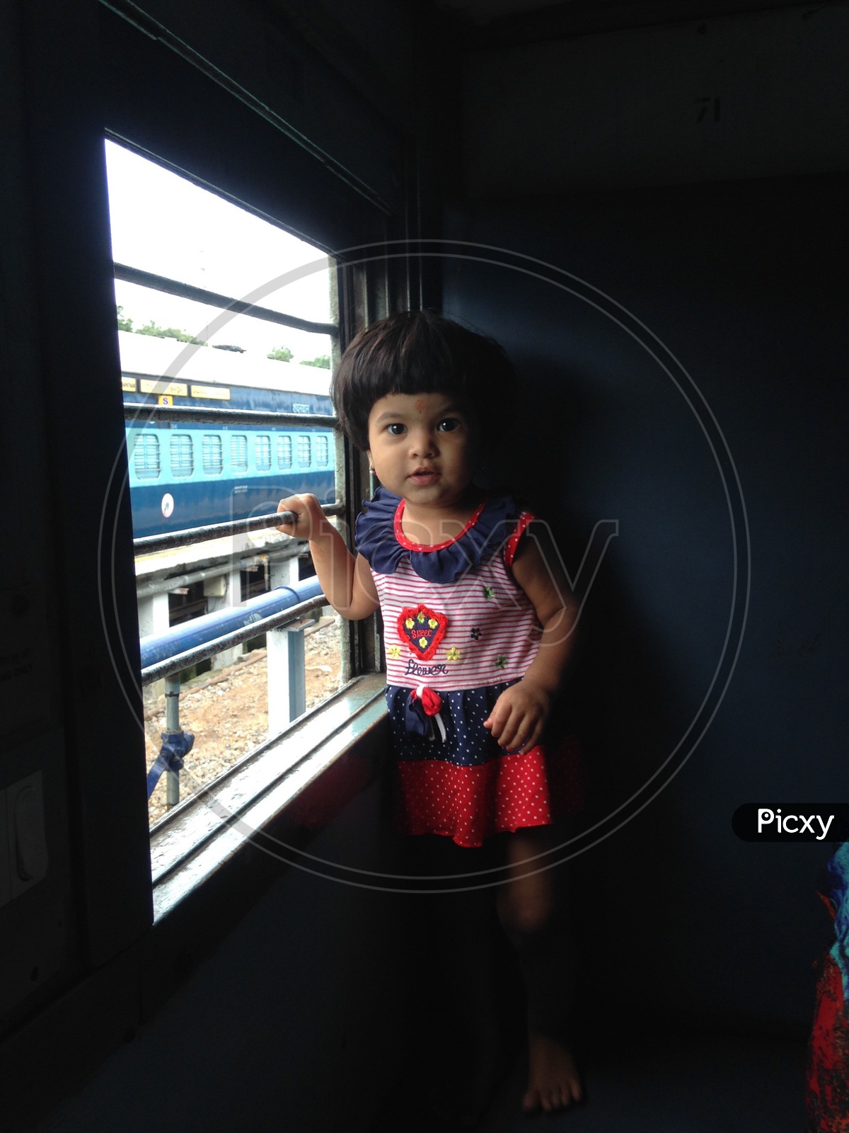 Small girl peeking outside the train window