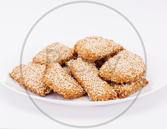 On a white plate, on a white background biscuits to sesame.