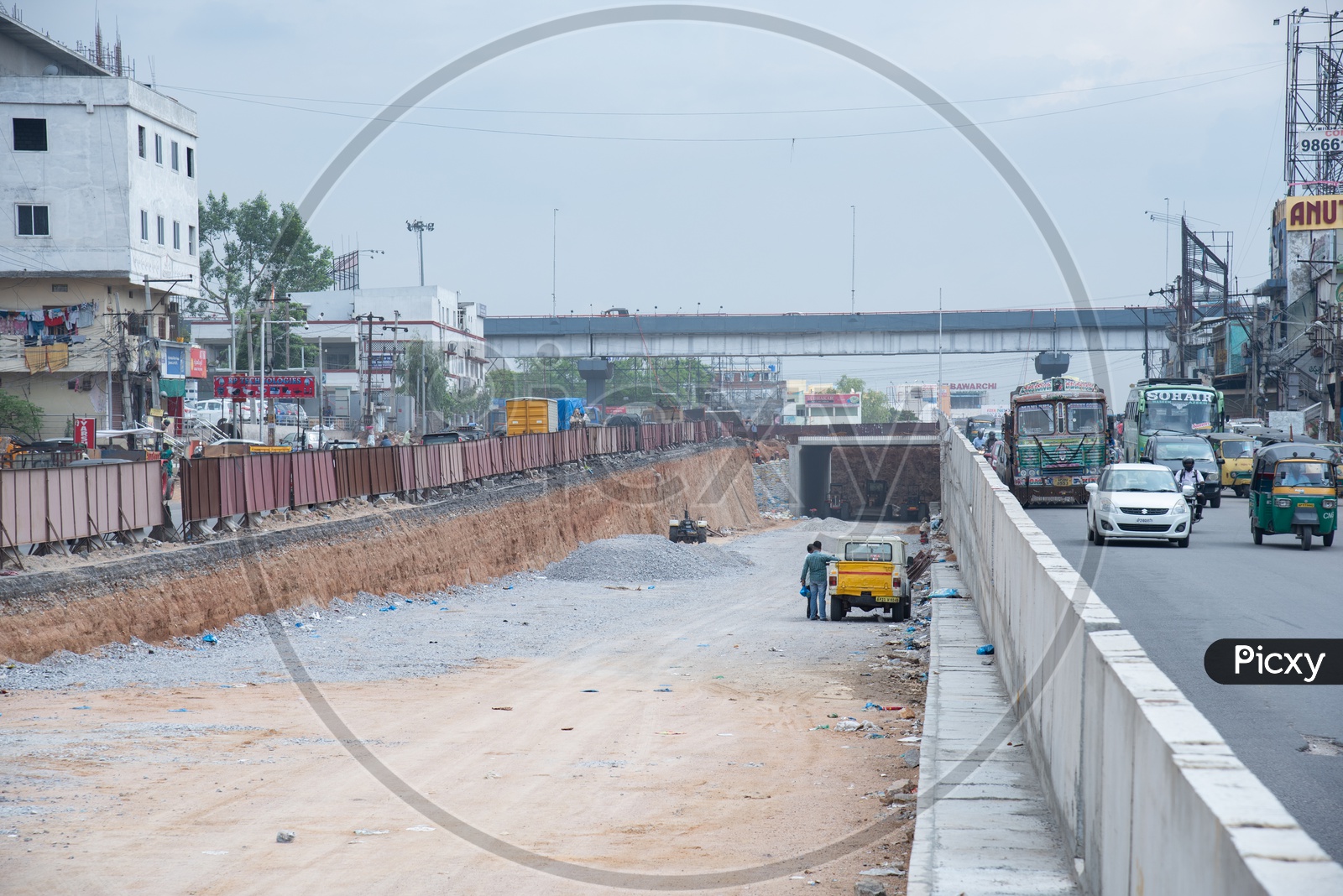 Construction Site Of a Flyover   At  Cities  With Commuting  Vehicles On The  Roads