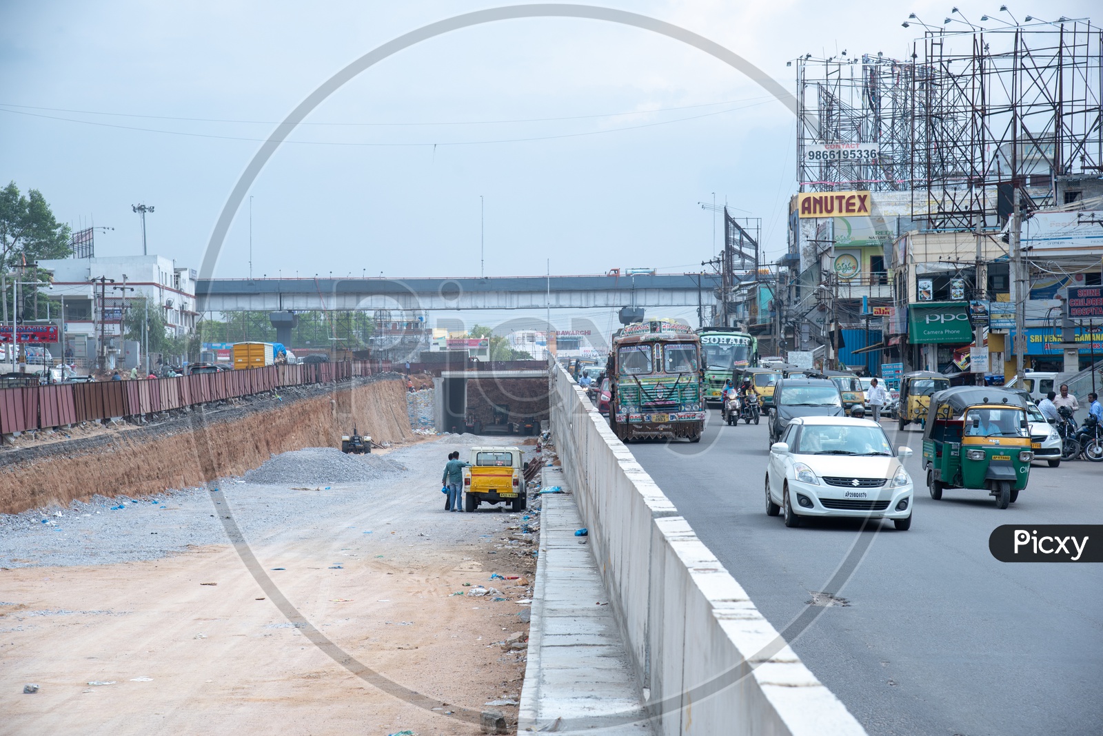 Construction Site Of a Flyover   At  Cities  With Commuting  Vehicles On The  Roads