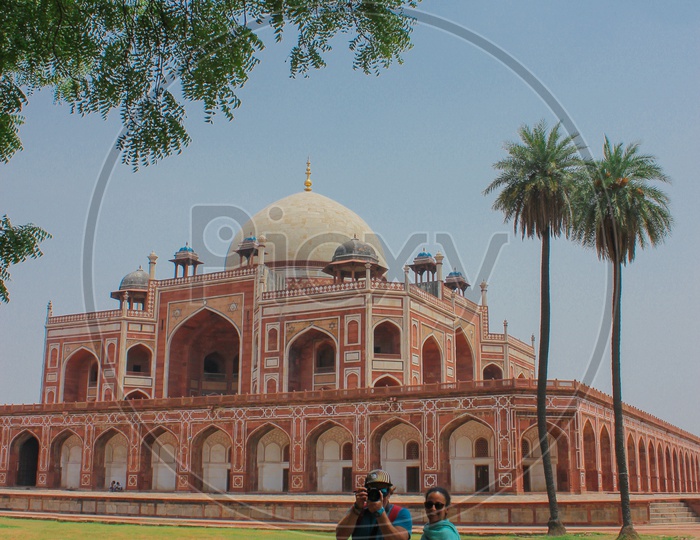 Two photographers capturing each other infront of the india's great historic architectural Humayun's tomb.