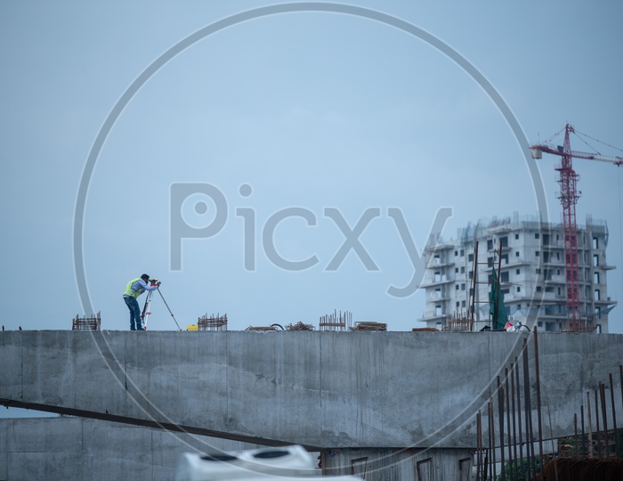 A Construction  Engineer at The Flyover Construction  With a Surveying Tool  on City Roads
