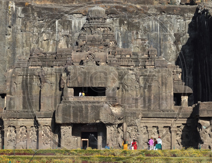 Tourists Or Visitors  At The Facade Of Ancient Stone  Carved  Ellora Caves