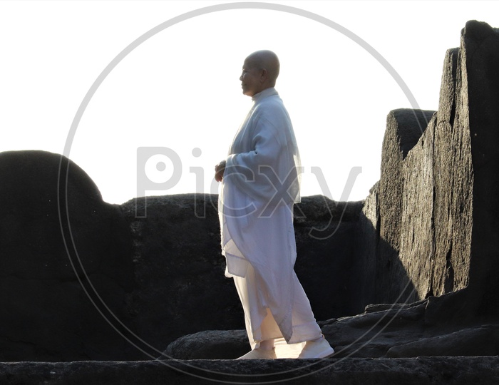 A Buddhist Monk In White Dress At Stone Carved   Ancient Buddhist Temple in Ellora Caves
