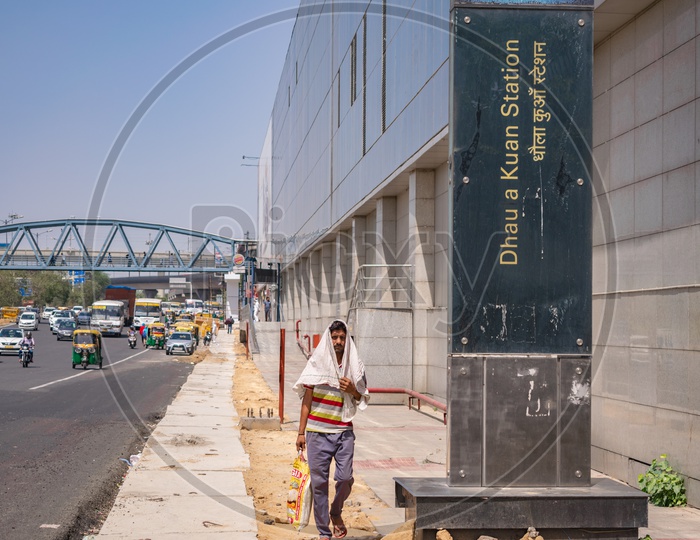 Dhaula Kuan metro station, foot over bridge at NH48 and a man covering his head due to harsh sunlight
