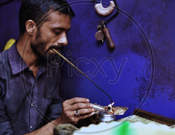 Silver smith working on jewellery.