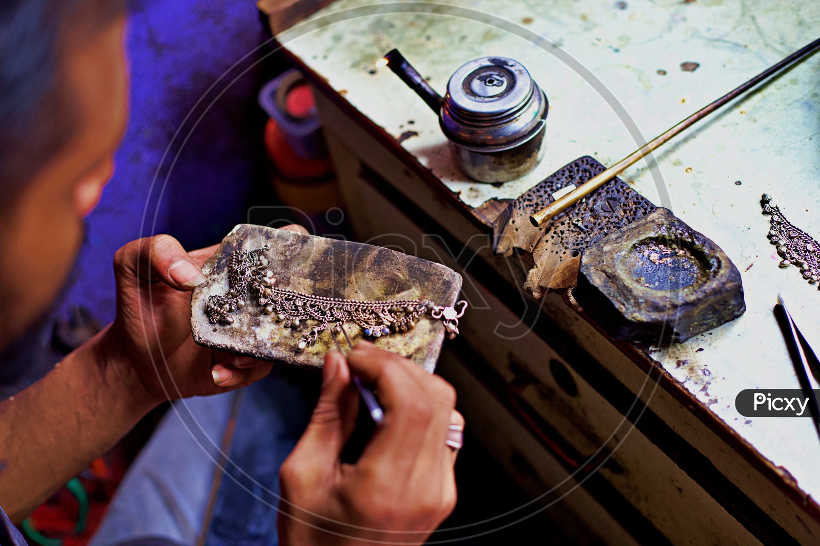 Silver smith working on jewellery.