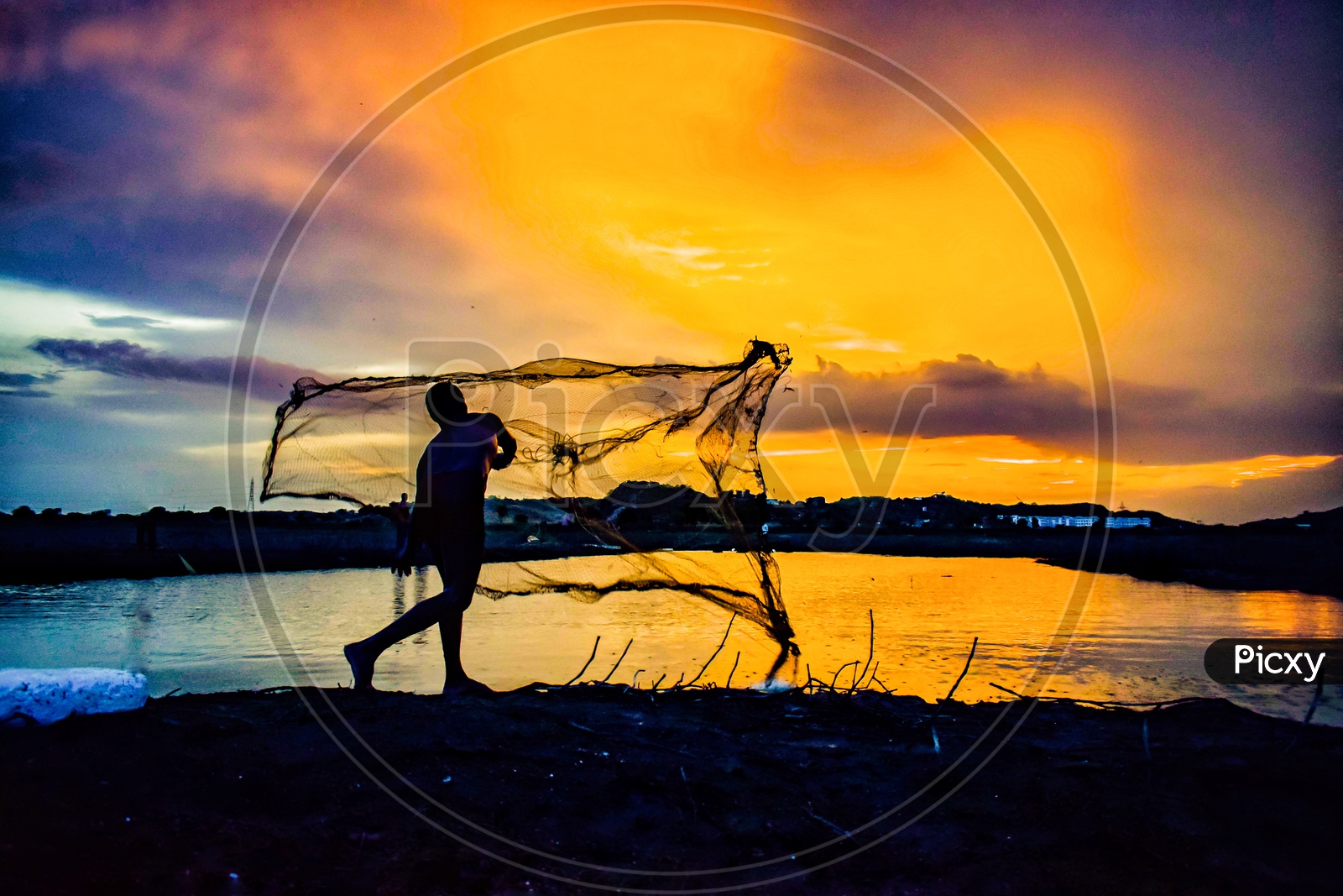 Silhouette of Fisher Man Throwing Fishing Net in a Fishing Pond with Sunset Sky In Background