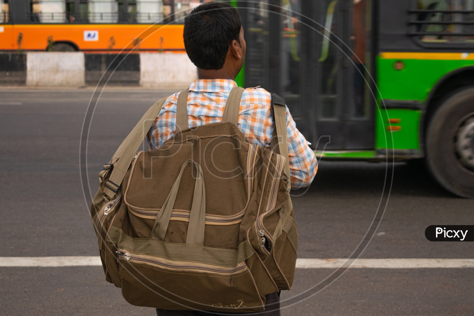 A man holding bag waiting for bus
