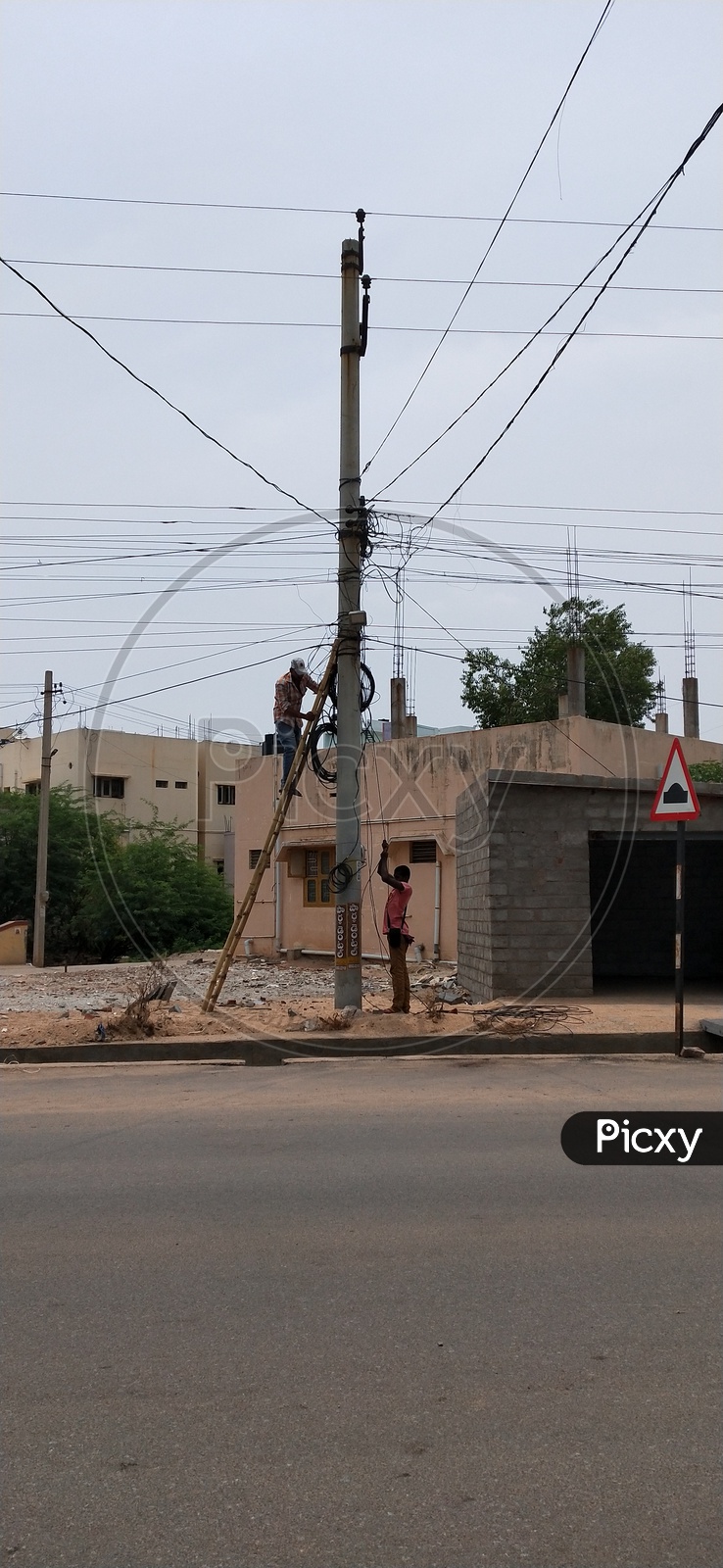Two workers repairing the electric pole in afternoon