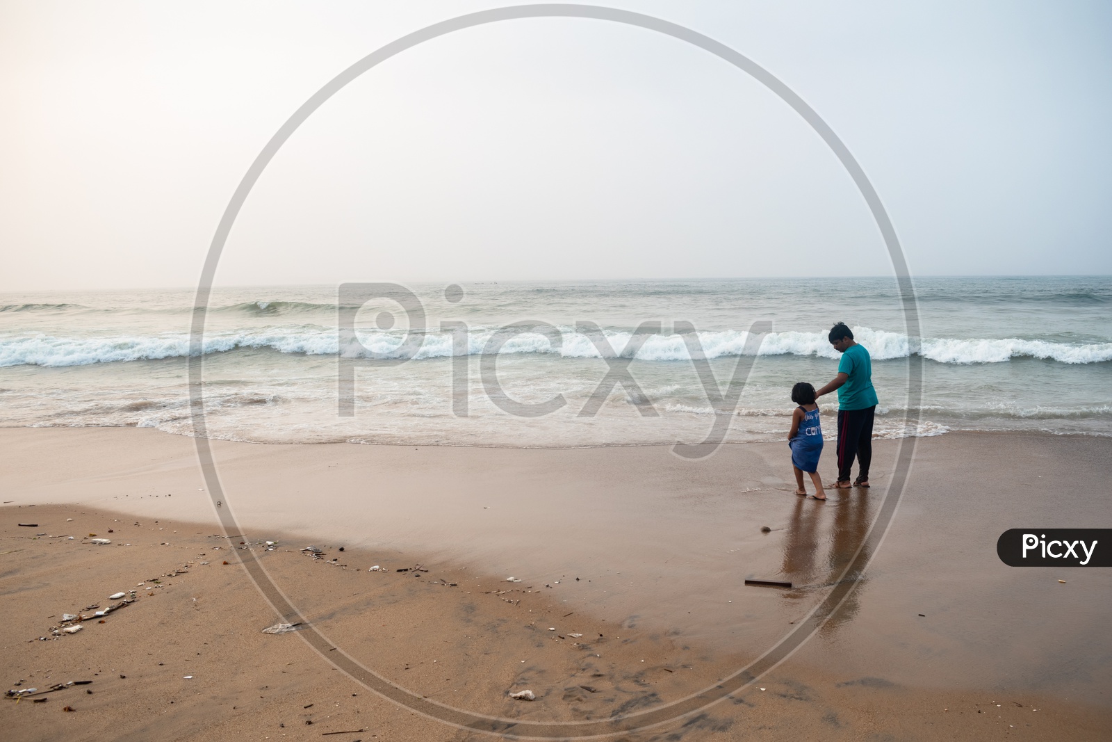 Father and Daughter standing at the shore and enjoying the beach view at Rama Krishna beach (R.K.Beach), Vishakapatnam/Vizag.