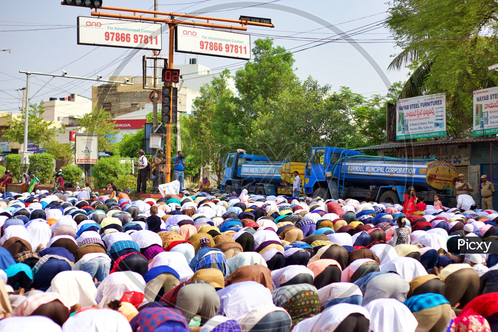 Muslims doing prayers under a traffic light.