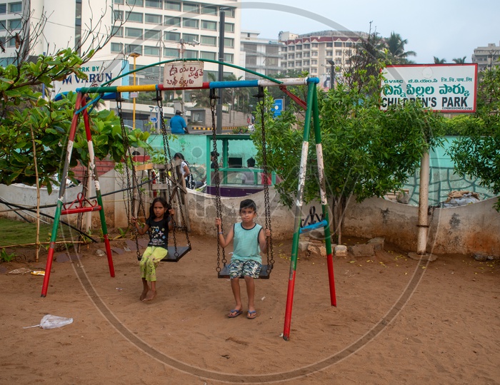 Kids playing swing at Children's park, Rama Krishna beach (R.K.Beach), Vishakapatnam/Vizag.