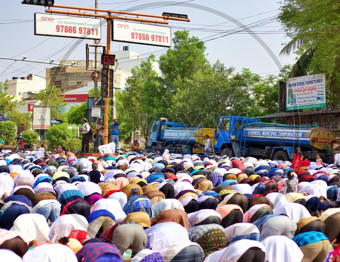 Muslims doing prayers under a traffic light.