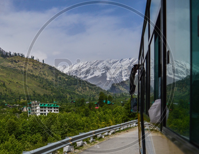 Roads With Commuting Vehicles With a View Of Snow Capped Mountains
