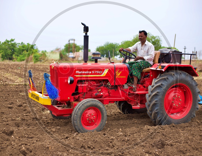 Farmer ploughing hi farm with tractor.
