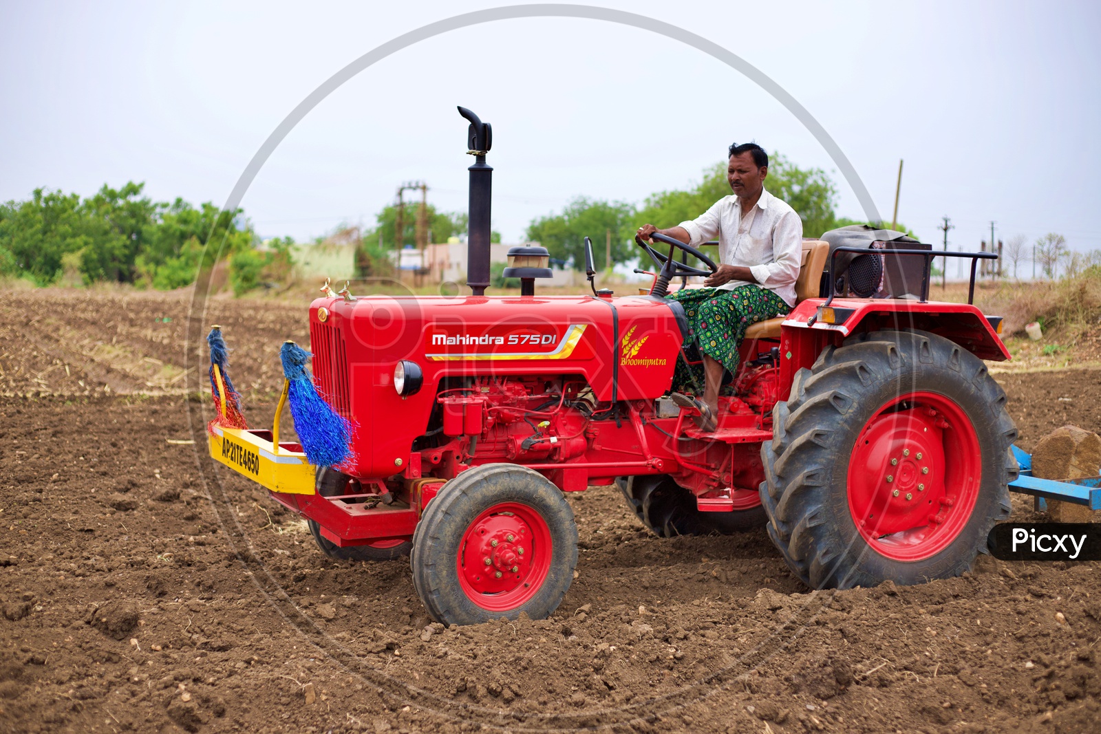 Farmer ploughing hi farm with tractor.