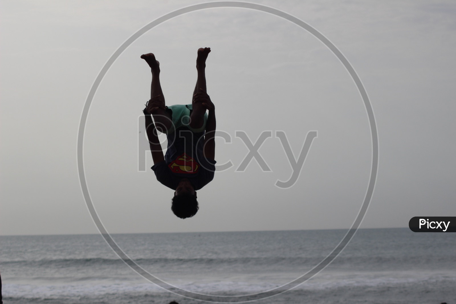 A Young Man Making Jumps Or Parkor Moves on the Beach