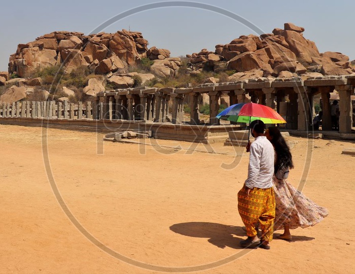 A Couple Carrying Umbrella From Bright Sun in Hampi