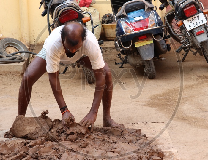 A Professional Potter Kneading Regur Soil for Making Pots